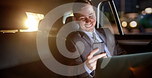 Businessman work on late night in back seat of car