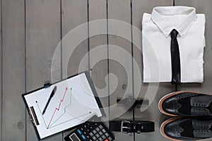 Businessman, work outfit on grey wooden background. White shirt with black tie, watch, belt, oxford shoes, planchette