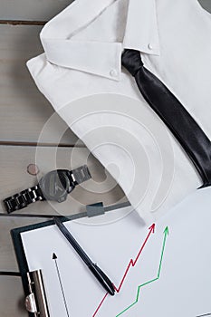 Businessman, work outfit on grey wooden background. White shirt with black tie, watch, belt, oxford shoes, planchette