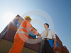 Businessman and worker with cargo containers