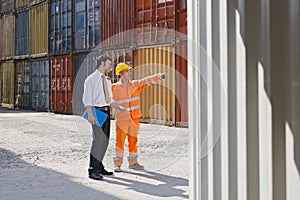 Businessman and worker with cargo containers