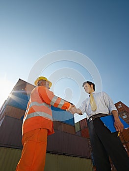 Businessman and worker with cargo containers