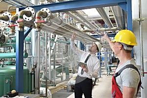 Businessman and worker meeting in a factory - maintenance and repair of the industrial plant