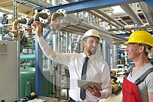 Businessman and worker meeting in a factory - maintenance and repair of the industrial plant