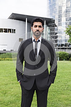 Businessman or worker in suit near office building