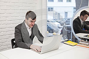 Businessman working in a bright modern office with a laptop