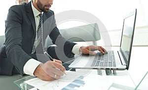 Businessman working with business graphics on a laptop computer