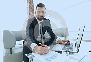 Businessman working with business graphics on a laptop computer