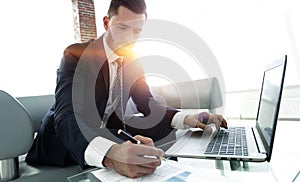 Businessman working with business graphics on a laptop computer