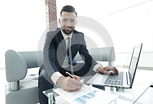 Businessman working with business graphics on a laptop computer