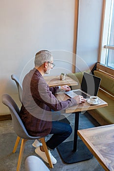 Businessman working in a cafe and looking seriosu