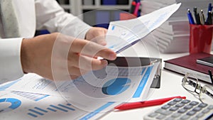 Businessman working and calculating, reads and writes reports. Office employee, table closeup. Business financial accounting conce