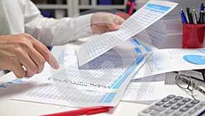 Businessman working and calculating, reads and writes reports. Office employee, table closeup. Business financial accounting conce