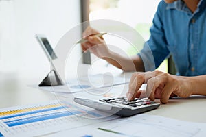 Businessman working with calculator and digital tablet. Account and Saving concept photo