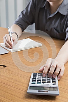 businessman working with calculator and notepad on office desk