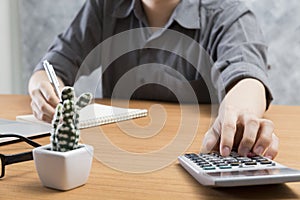 businessman working with calculator and notepad on office desk