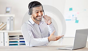 Businessman working in a call center. Customer service agent talking to a customer. Sales rep wearing a headset using a