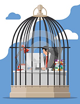 Businessman working on computer in the bird cage.