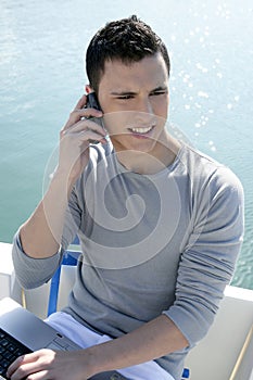 Businessman working with computer on a boat