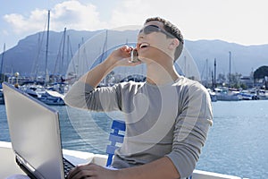 Businessman working with computer on a boat