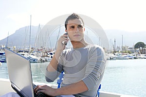 Businessman working with computer on a boat