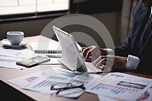Businessman working on computer, drinking coffee and smiling