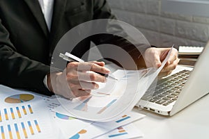 Businessman working with computer and looking at the document in office. Business and technology, financial concept. Closeup