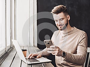 Businessman working on computer. Man using smart phone and laptop in the office. Internet marketing, finance, business concept