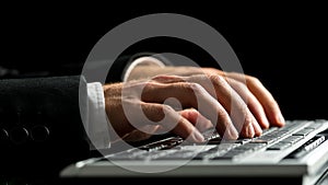 Businessman working on computer by typewriting on the keyboard photo