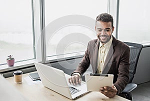 Businessman working on computer. Young men using digital tablet and laptop in office. Internet marketing, finance, business concep