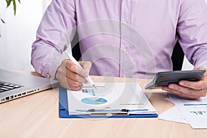 Businessman working on a desk. Freelance work at home office. Writing note on a book. Time racing. Soft focus.