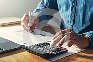 businessman working on desk office with using a calculator to calculate budget, finance concept