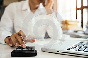 Businessman working on desk office with using a calculator to calculate tax