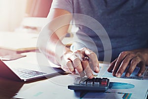 businessman working on desk using calculator to calculate data of finance