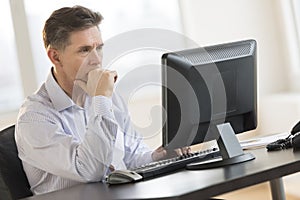 Businessman Working On Desktop Pc In Office photo