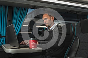 Businessman Working on His Laptop Inside Coach Bus on Long International Haul