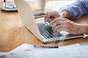 Businessman working on home office. Man sitting wood table and using contemporary notebook, texting message keyboard.