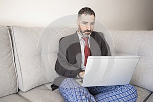 Businessman working at home wearing a suit and pajama pants