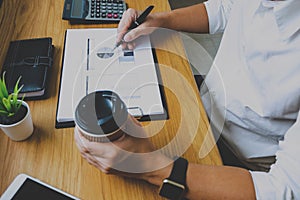 Businessman working with income statement document on the wood table.Business concept