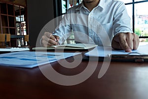 Businessman working with income statement document on the wood table.Business concept