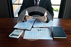 Businessman working with income statement document on the wood table.Business concept