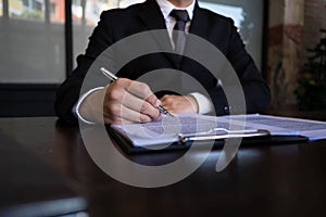 Businessman working with income statement document on the wood table.Business concept