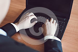 Businessman working on keyboard computer laptop man sitting on the table and using internet technology at workplace in office -