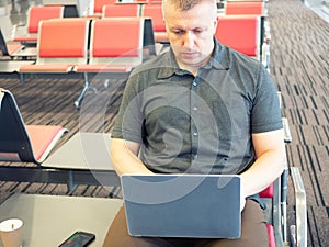 Businessman working on laptop at the airport