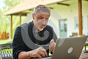 Businessman working with laptop computer at home outdoor in garden