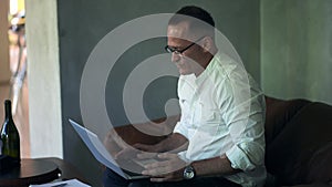 An businessman working on laptop computer. Male professional typing on laptop keyboard at caffe. Portrait of positive