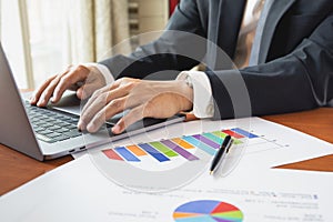 Businessman working with laptop with graph stock chart on table work from home concept.