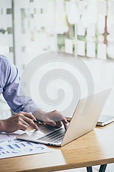 Businessman working laptop for new architectural project. Generic design notebook on the table. Blurred background, vertical