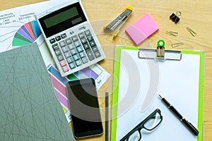 Businessman working on a laptop at office desk with paperwork