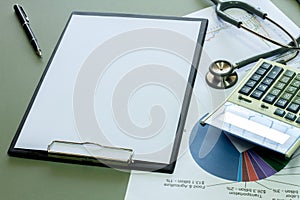 Businessman working on a laptop at office desk with paperwork